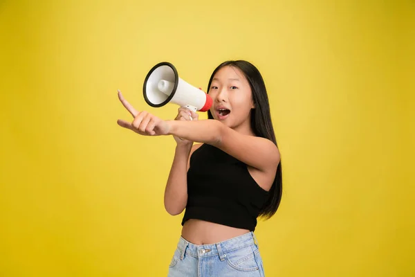 Portrét mladé asijské dívky izolované na žlutém pozadí studia — Stock fotografie