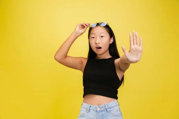 Retrato de jovem ásia menina isolado no amarelo estúdio fundo — Fotografia de Stock
