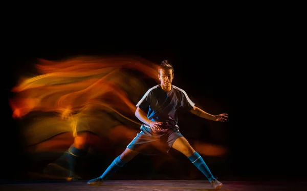 Giocatore di calcio o di calcio su sfondo nero in luce mista, ombre di fuoco — Foto Stock