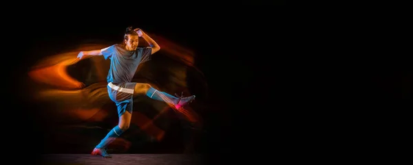 Fotboll eller fotbollsspelare på svart bakgrund i blandat ljus, brand skuggor — Stockfoto