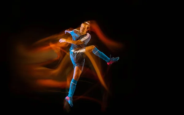 Futebol ou jogador de futebol em fundo preto em luz mista, sombras de fogo — Fotografia de Stock