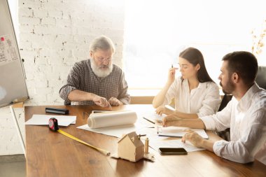 Erkek mimar-mühendis, genç aile için müstakbel ev projesini sunar..