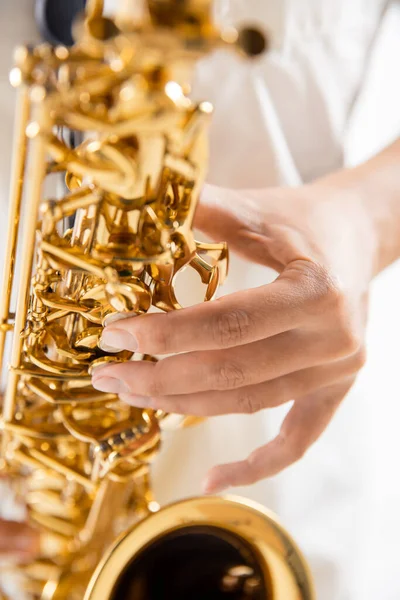 Close up woman playing saxophone isolated on white studio background — Stock Photo, Image