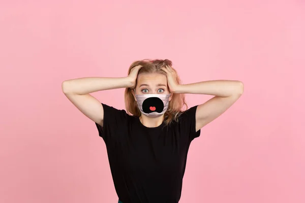 Porträtt av ung flicka med känslor på hennes skyddande ansiktsmask isolerad på studio bakgrund. Vacker kvinnlig modell, roligt uttryck — Stockfoto