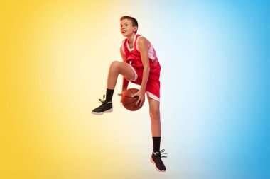 Gradyan arka planda topu olan genç bir basketbolcunun tam boy portresi