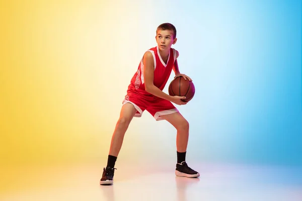 Helaftens portrett av en ung basketballspiller med ball på gradient bakgrunn – stockfoto