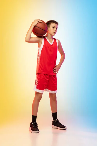 Retrato de comprimento total de um jovem jogador de basquete com bola no fundo gradiente — Fotografia de Stock