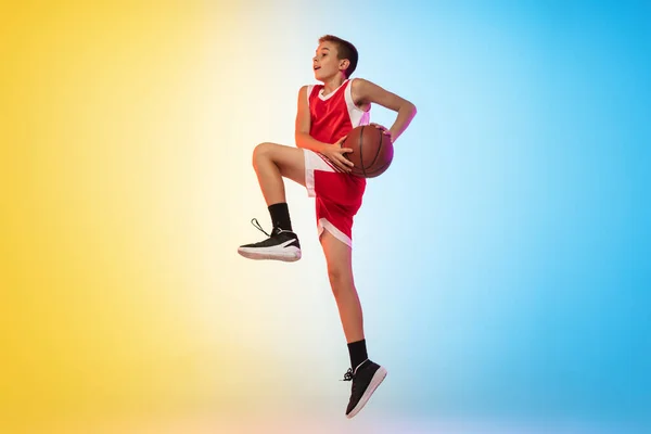 Портрет молодого баскетболиста с мячом на градиентном фоне — стоковое фото
