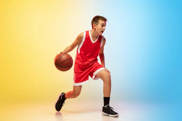 Full length portret van een jonge basketbalspeler met bal op gradiënt achtergrond — Stockfoto