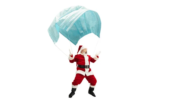 Père Noël volant sur un énorme masque facial comme sur un ballon isolé sur fond blanc — Photo