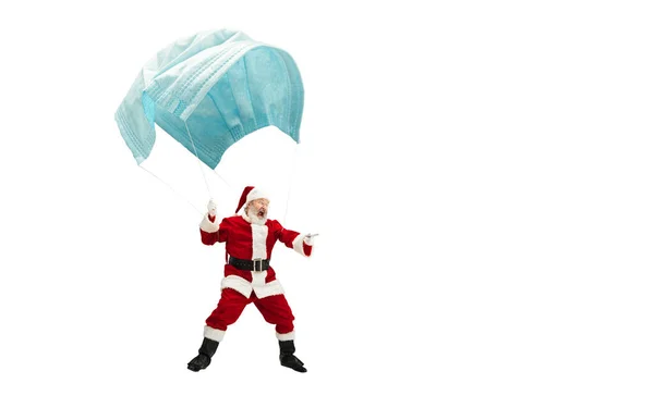 Santa Claus volando sobre una enorme máscara facial como en un globo aislado sobre fondo blanco — Foto de Stock