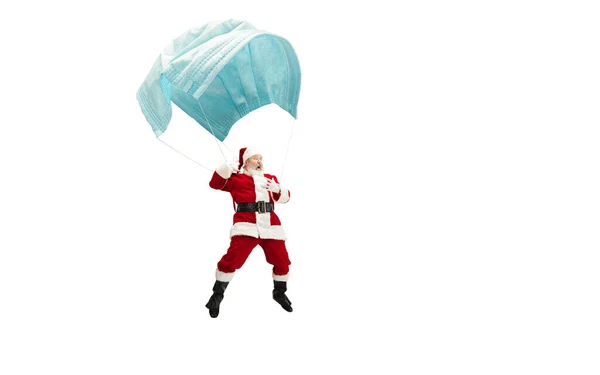 Santa Claus létání na obrovské obličejové masky jako na balónu izolované na bílém pozadí — Stock fotografie