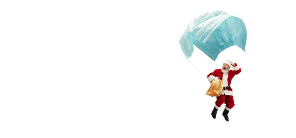 Santa Claus volando sobre una enorme máscara facial como en un globo aislado sobre fondo blanco —  Fotos de Stock
