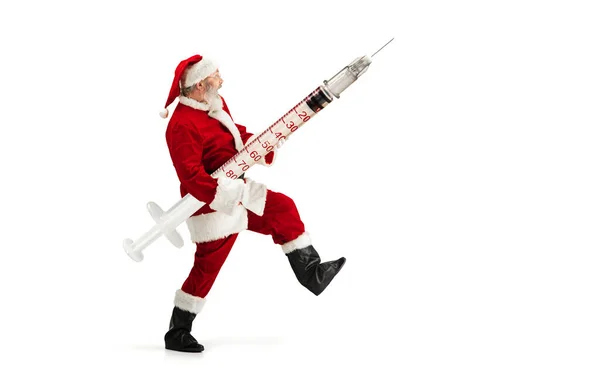 Weihnachtsmann hält riesigen Impfstoff gegen COVID wie Weihnachtsgeschenk isoliert auf weißem Hintergrund — Stockfoto