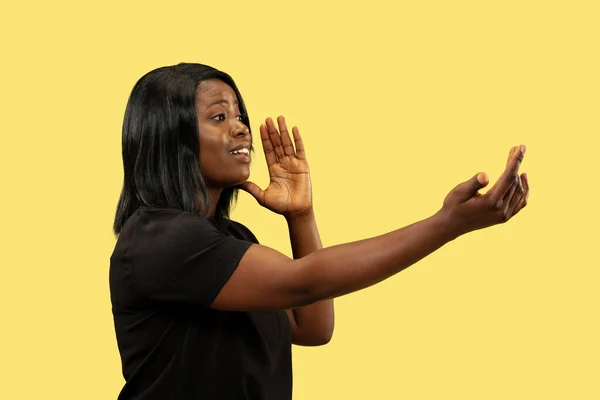 Mujer africana joven aislada sobre fondo de estudio amarillo, expresión facial —  Fotos de Stock