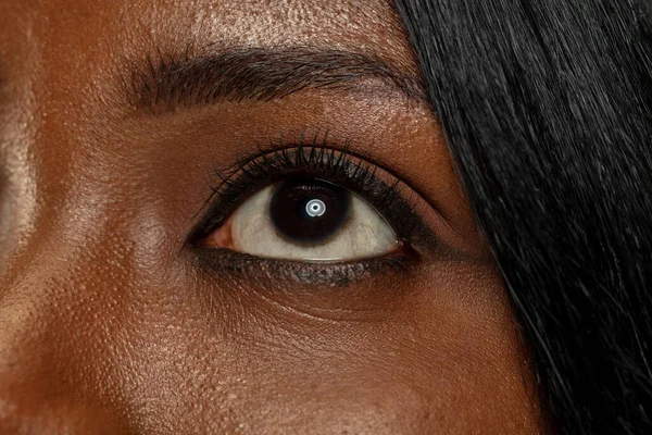 Jeune femme africaine isolée sur fond de studio jaune, expression faciale — Photo