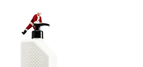 Noel Baba, COVID 'e karşı büyük antiseptikleri olan beyaz arka planda izole edilmiş bir Noel hediyesi gibi. — Stok fotoğraf