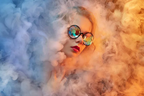 Giovane bella donna su neon colorato studio sfondo in nuvola di fumo. Emozioni umane, espressione facciale, concetto di bellezza. — Foto Stock