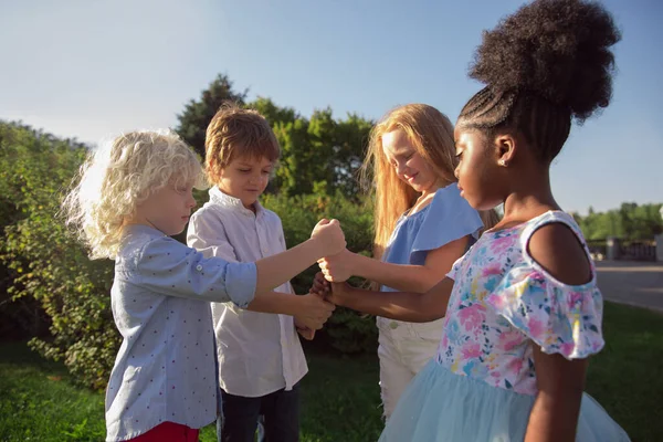 Interracial group of kids, girls and boys playing together at the park in summer day — Stock Photo, Image