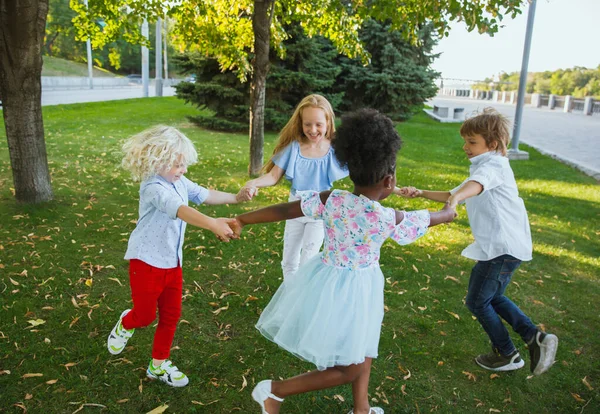 Groupe interracial d'enfants, de filles et de garçons jouant ensemble au parc pendant la journée d'été — Photo
