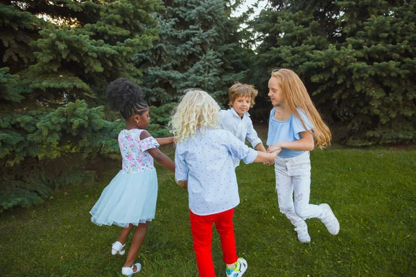 Groupe interracial d'enfants, de filles et de garçons jouant ensemble au parc pendant la journée d'été — Photo