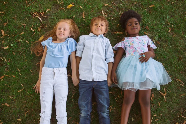 Grupo interracial de niños, niñas y niños jugando juntos en el parque en el día de verano — Foto de Stock