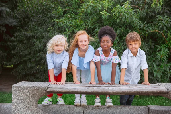 Groupe interracial d'enfants, de filles et de garçons jouant ensemble au parc pendant la journée d'été — Photo