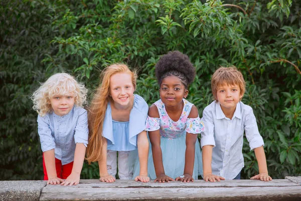 Groupe interracial d'enfants, de filles et de garçons jouant ensemble au parc pendant la journée d'été — Photo