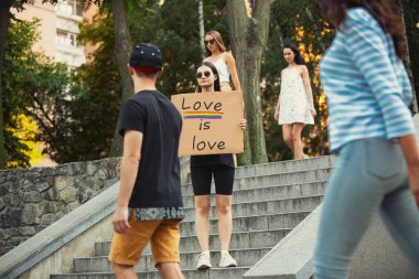 Tabelalı adam. Kadın onu kızdıran şeyleri protesto ediyor.