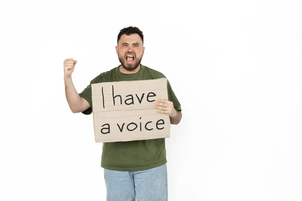 Ung man protesterar isolerad på vit studio bakgrund. Aktivism, aktiv social ställning, protest, faktiska problem. — Stockfoto