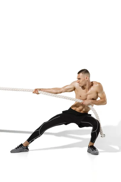 Mooie jonge mannelijke atleet oefenen op witte studio achtergrond met schaduwen — Stockfoto