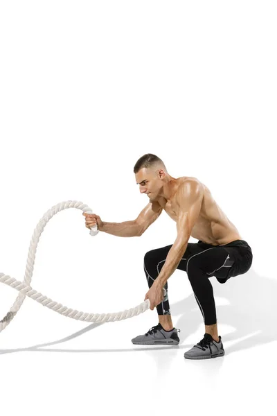 Mooie jonge mannelijke atleet oefenen op witte studio achtergrond met schaduwen — Stockfoto