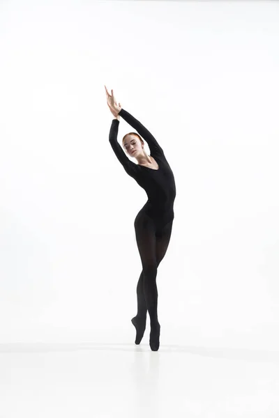 Jeune et gracieux danseur de ballet dans un style noir minimal isolé sur fond de studio blanc — Photo