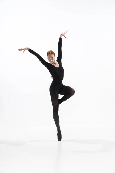 Mladý a elegantní baletní tanečník v minimálním černém stylu izolované na bílém pozadí studia — Stock fotografie