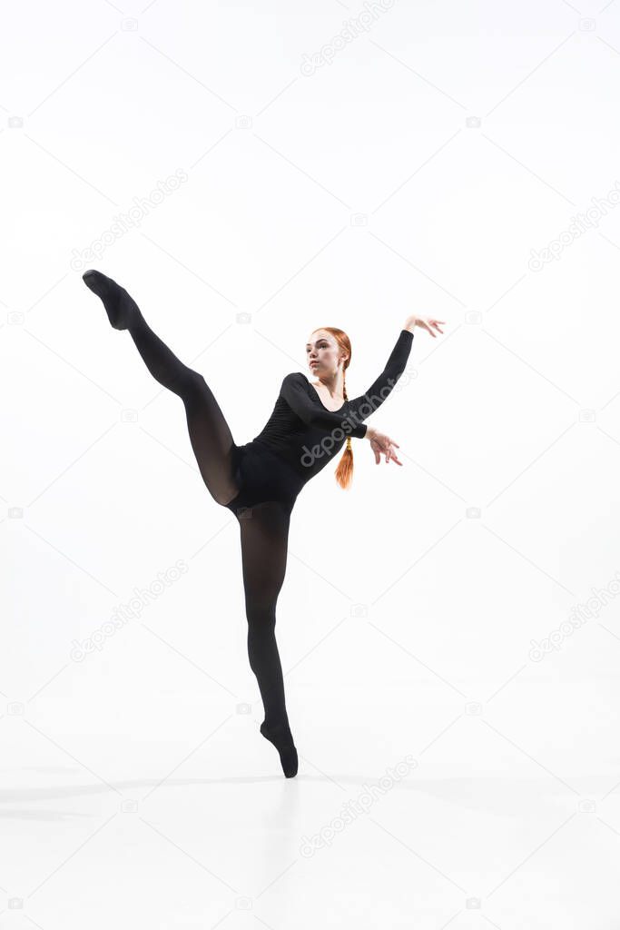 Young and graceful ballet dancer in minimal black style isolated on white studio background