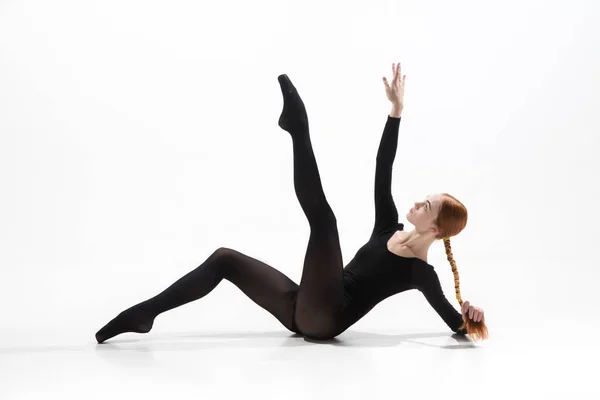 Joven y elegante bailarina de ballet en estilo minimalista negro aislado sobre fondo de estudio blanco — Foto de Stock