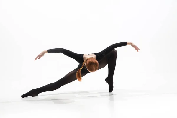 Junge und anmutige Balletttänzerin im minimalen schwarzen Stil isoliert auf weißem Studiohintergrund — Stockfoto