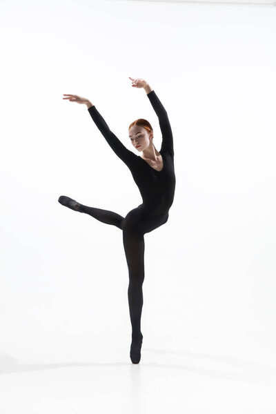 Young and graceful ballet dancer in minimal black style isolated on white studio background