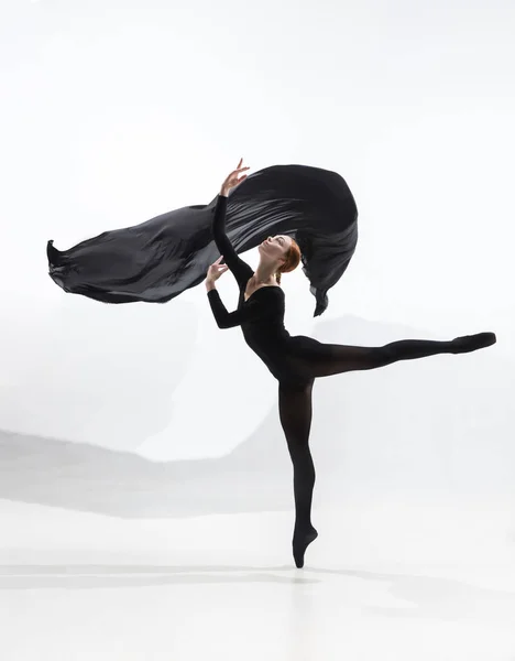 Joven y elegante bailarina de ballet en estilo minimalista negro aislado sobre fondo de estudio blanco — Foto de Stock