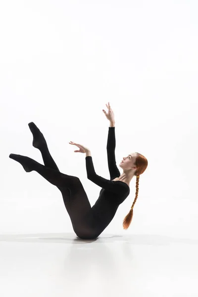 Młoda i pełna wdzięku tancerka baletowa w minimalnym czarnym stylu odizolowana na białym tle studio — Zdjęcie stockowe