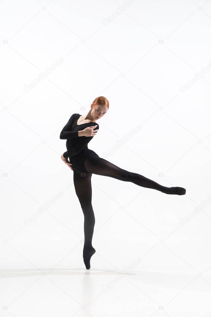 Young and graceful ballet dancer in minimal black style isolated on white studio background