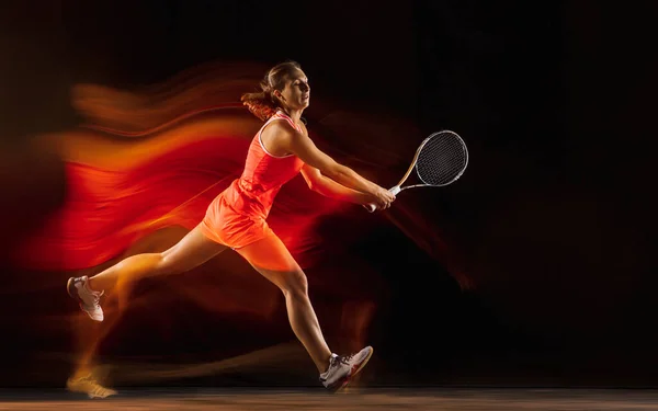 Jugadora de tenis profesional aislada sobre fondo de estudio negro en luz mixta —  Fotos de Stock