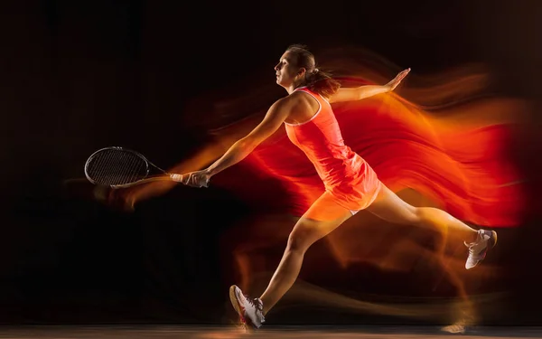 Professionele vrouwelijke tennisspeler geïsoleerd op zwarte studio achtergrond in gemengd licht — Stockfoto