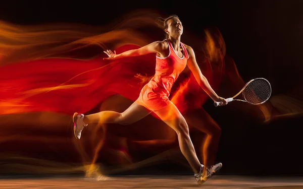 Giocatrice professionista di tennis isolata su sfondo nero in luce mista — Foto Stock