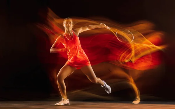 Professionell kvinnlig tennisspelare isolerad på svart studio bakgrund i blandat ljus — Stockfoto