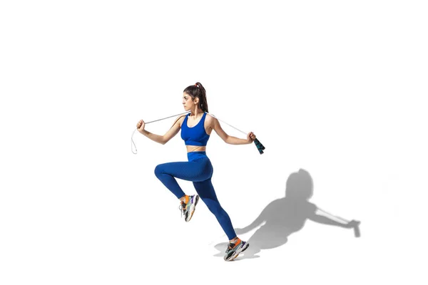 Hermosa joven atleta practicando en el fondo blanco del estudio con sombras — Foto de Stock