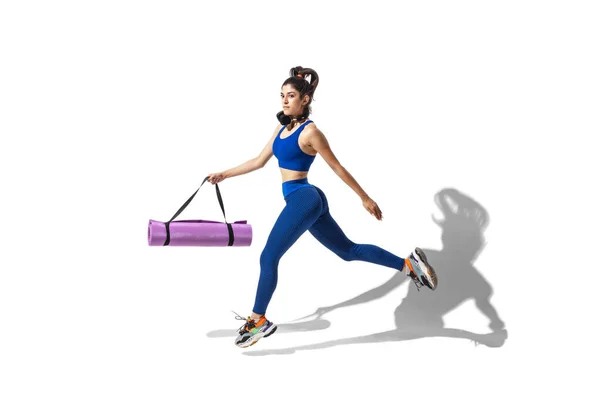 Hermosa joven atleta practicando en el fondo blanco del estudio con sombras — Foto de Stock