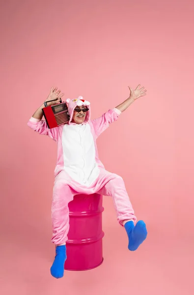 Senior hipster man in stylish pink attire isolated on pink background. Tech and joyful elderly lifestyle concept — Stock Photo, Image