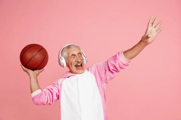 Homem hipster sênior em traje rosa elegante isolado em fundo rosa. Conceito de tecnologia e estilo de vida idoso alegre — Fotografia de Stock