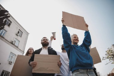 Bir grup aktivist mitingde slogan atıyorlar. Erkekler ve kadınlar şehirde bir protestoda birlikte yürüyorlar..